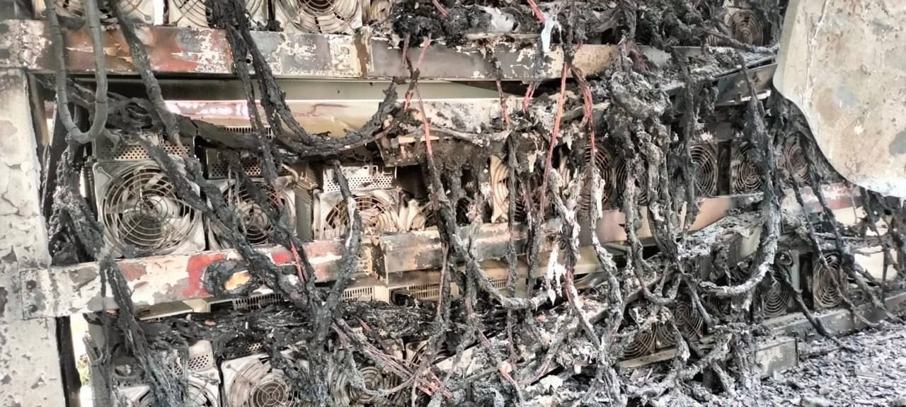 Melted power cables draped over burned miners